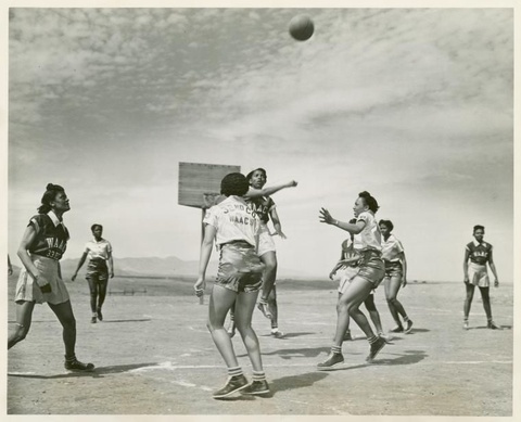A black-and-white photograph depicts eight African American women wearing short sleeve shirts, skirt