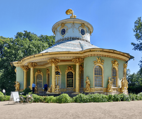 Daytime view of the blue-green Chinese Tea House at Sanssouci, a circular pavilion with a lanterned-