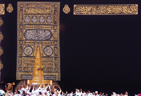 A large black textile densely embroidered in places with gold and silver Arabic calligraphy forming 