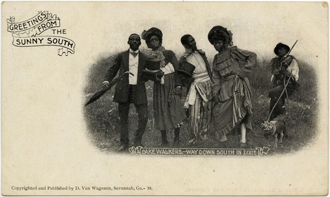 A group of African American men and women dressed in 19th century costumes pose in front of a grassy