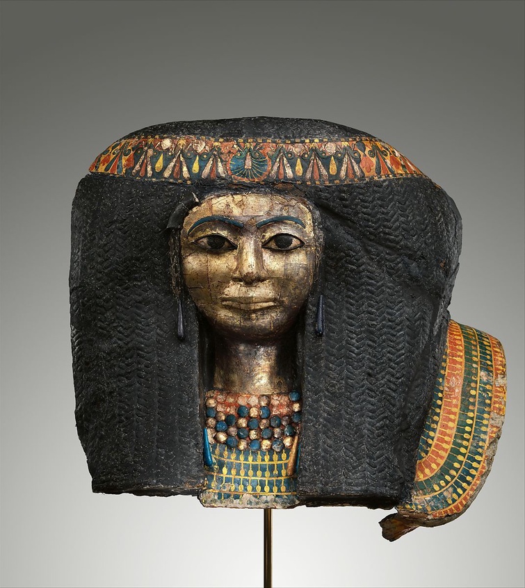 A New Kingdom funerary mask of a woman. She wears a braided wig, painted headband, and beaded neckla