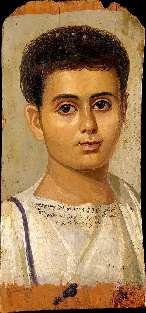 A lifelike portrait of a young boy in a white tunic with a Greek inscription across the chest listin